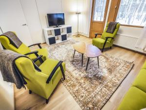 salon z zielonymi krzesłami i dywanem w obiekcie Holiday Home Mäntyranta 4 by Interhome w mieście Punkaharju