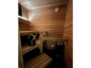 a wooden sauna with a bucket on the stairs at Holiday Home Rakkaranta a- lentäjän poika 1 by Interhome in Hyrynsalmi
