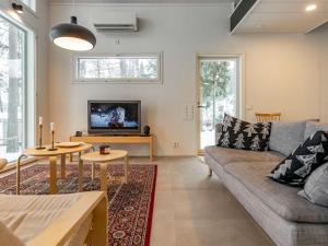 a living room with a couch and a tv at Holiday Home Villa honkarinne by Interhome in Jyväskylä