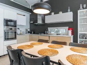 a dining room with a table with chairs and a kitchen at Holiday Home Villa honkarinne by Interhome in Jyväskylä