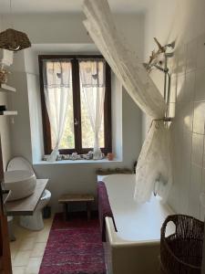 baño con bañera y ventana en Casa della Nonna, en Porretta Terme