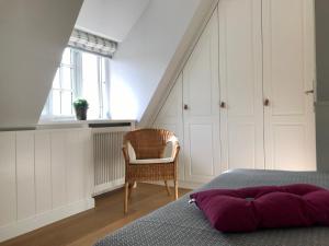 a bedroom with a bed and a chair at Haus Muehlenblick in Borgsum