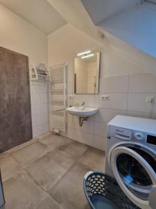 een badkamer met een wasmachine en een wastafel bij Haus Riehe - b50841 in Haselünne