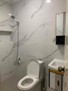 a white bathroom with a toilet and a sink at Marias Island Oasis close to the airport and resorts in Pajak +18 photos