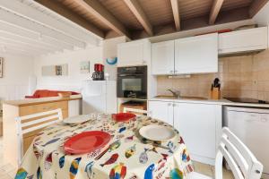 a kitchen with a table with red plates on it at Évasion et détente à Saint-Gildas-de-Rhuys in Saint-Gildas-de-Rhuys +9 photos