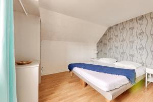 niewielka sypialnia z łóżkiem z niebieską i białą pościelą w obiekcie Evasion et detente a Saint-Gildas-de-Rhuys w mieście Saint-Gildas-de-Rhuys