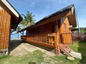 a wooden house with a porch on the beach at Hola Beach Resort in Siquijor