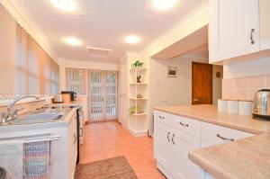 a kitchen with white cabinets and a sink at The Bays in Bowcombe