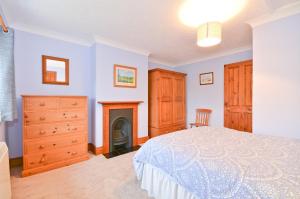 a bedroom with a bed and a fireplace at The Bays in Bowcombe