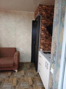 a living room with a couch and a brick wall at Hotel Kobuleti in K'obulet'i