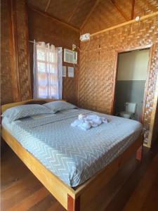 a bedroom with a bed in a wooden room at Hola Beach Resort in Siquijor