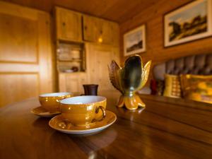 dos tazas y platillos sentados en una mesa de madera en Holiday Home Laderen 7 by Interhome, en Oberegg