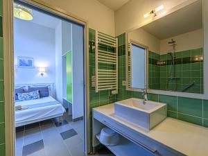 uma casa de banho com um lavatório, um espelho e uma cama em Apartment Le Château de Kergonano-21 by Interhome em Baden