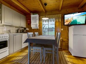 a kitchen with a table with chairs and a tv at Holiday Home Missi by Interhome 