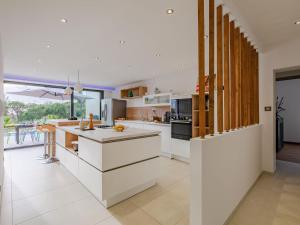 une cuisine avec comptoirs blancs et une grande fenêtre dans l'établissement Villa Les Girelles by Interhome, aux Issambres