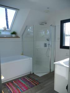 uma casa de banho com uma cabina de duche em vidro e um lavatório. em La Villa sous Les Pins em La Trinité-sur-Mer