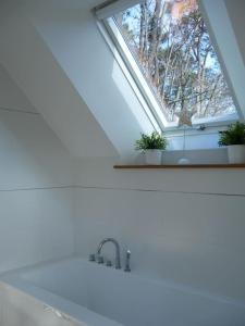 uma clarabóia na casa de banho com um lavatório e uma janela em La Villa sous Les Pins em La Trinité-sur-Mer