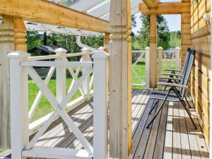 eine Holzterrasse mit zwei Stühlen darauf in der Unterkunft Holiday Home Wooden ecovilla by Interhome in Haapalahti