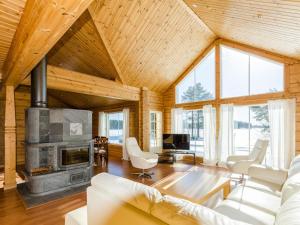 a living room with a fireplace and wooden ceilings at Holiday Home Wooden ecovilla by Interhome in Haapalahti