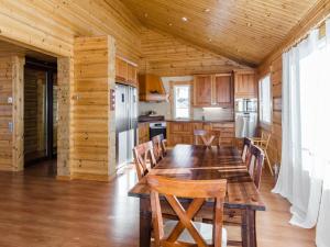 a wooden kitchen with a wooden table and chairs at Holiday Home Wooden ecovilla by Interhome in Haapalahti
