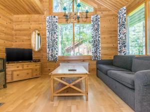 ein Wohnzimmer mit einem Sofa und einem TV in der Unterkunft Holiday Home Karpalo 3 by Interhome in Isnäs