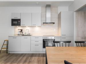 Una cocina con gabinetes blancos y una mesa y sillas. en Holiday Home Dagmarin kulma by Interhome, en Ylivieska