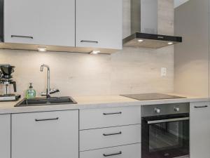 Una cocina con gabinetes blancos y un fregadero. en Holiday Home Dagmarin kulma by Interhome, en Ylivieska