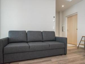 un sofá gris en una sala de estar con puerta en Holiday Home Dagmarin kulma by Interhome, en Ylivieska