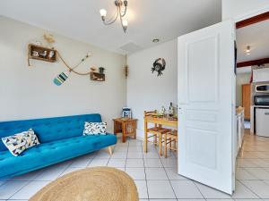 ein Wohnzimmer mit einem blauen Sofa und einer Küche in der Unterkunft Holiday Home by Interhome 