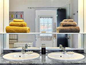 ein Badezimmer mit 2 Waschbecken und einem Spiegel in der Unterkunft Holiday Home by Interhome 