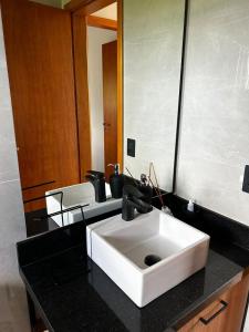 uma casa de banho com um lavatório branco e um espelho. em Cabana em São Luíz do Puruna em Balsa Nova