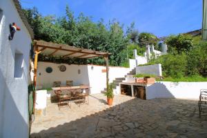 een patio met een houten tafel en stoelen en een tafel bij El Balcón de Linares by SIERRA VIVA in Linares de la Sierra +23 foto's
