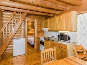 kuchnia z drewnianymi szafkami i schody w drewnianym domku w obiekcie Holiday Home Iso mökki by Interhome w mieście Haapalahti