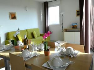 uma sala de jantar com uma mesa e um sofá verde em Apartment Château de Jouarres-3 by Interhome em Azille