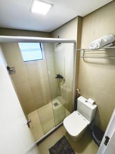 a bathroom with a toilet and a glass shower at Deluxe Rooms By Booking Fortaleza in Fortaleza