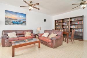 Una sala de estar con dos sofás de cuero y una mesa. en Casa Clare Frigiliana, en Frigiliana