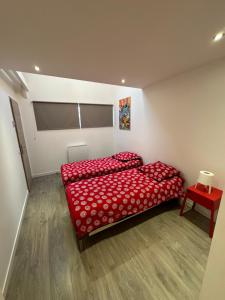 a bedroom with two red beds and a red table at LOFT, MAISON de VILLE de 100m2, 7 lits in Bagnolet