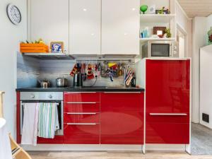 una cocina roja y blanca con armarios blancos en Holiday Home Kivilahti by Interhome, en Jämsä