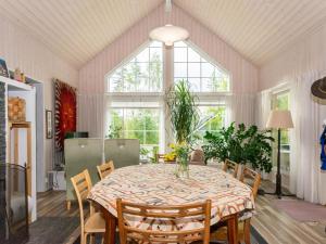 comedor con mesa, sillas y ventanas en Holiday Home Kivilahti by Interhome, en Jämsä