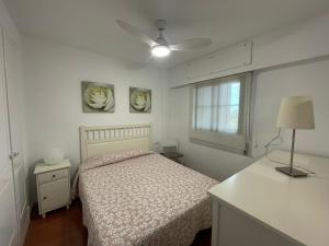 um quarto com uma cama e duas fotografias na parede em Apartamento premium un dormitorio ALCAUDON na Isla Canela