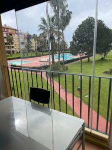 um quarto com uma mesa e vista para uma piscina em Apartamento premium un dormitorio ALCAUDON na Isla Canela