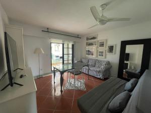 uma sala de estar com um sofá e uma mesa em Apartamento premium un dormitorio ALCAUDON na Isla Canela