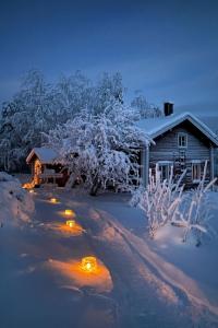 uma casa coberta de neve com luzes no quintal em Holiday Home Laattajan hirsipirtti by Interhome em Hyrynsalmi