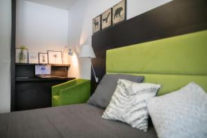 a bedroom with a bed with a green headboard at Apartment Silver Deer, Kranjska Gora in Kranjska Gora