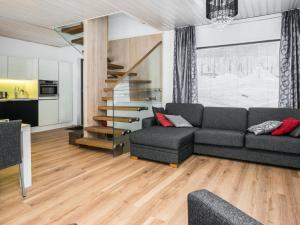 ein Wohnzimmer mit einer Couch und einer Treppe in der Unterkunft Holiday Home Villa rauha by Interhome in Imatra