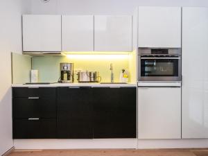 eine Küche mit schwarz-weißen Schränken und Geräten in der Unterkunft Holiday Home Villa rauha by Interhome in Imatra + 12 Fotos