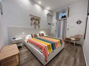 マルゲリータ・ディ・サヴォイアにあるCanzone del soleのベッドルーム1室(カラフルな毛布付きのベッド1台付)