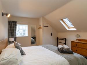 a bedroom with a large white bed and a skylight at Holiday Home Railway House by Interhome in Aviemore