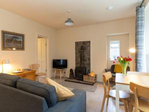 a living room with a couch and a fire place at Holiday Home Railway House by Interhome in Aviemore