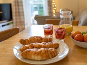 a plate of croissants and oranges on a table at Holiday Home Railway House by Interhome in Aviemore